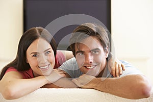 Couple Watching Widescreen TV At Home