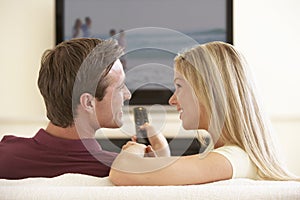 Couple Watching Widescreen TV At Home