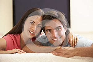 Couple Watching Widescreen TV At Home