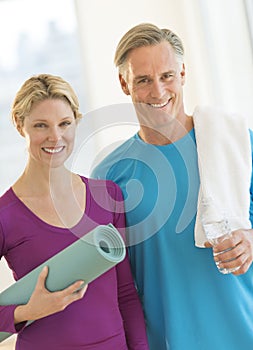 Couple With Water Bottle; Exercise Mat And Towel In Gym