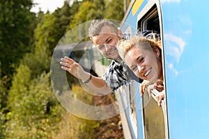 Couple waving with heads out train window