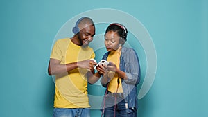 Couple wearing headphones and listening to music with mobile phone