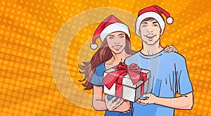 Couple Wearing Santa Hats Hold Gift Happy Man And Woman On Comin Poster Pin Up Background Winter Holidays Concept photo