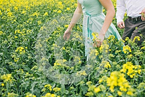 Couple before wedding running in colza field