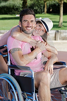 Couple in wheelchair strolling in park