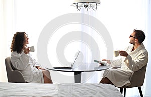 Couple in white bathrobe on a table in a hotel.