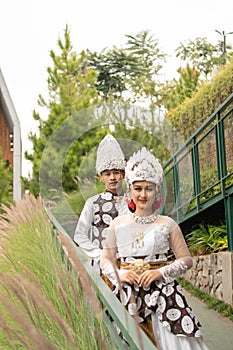 a couple in white clothes posing very intimately and intimately in a park