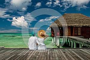 Couple in white on a tropical beach jetty