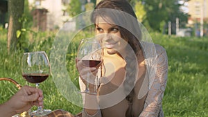 Couple with wineglasses on picnic in the park