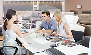 Couple wit seller consulting about color for new sofa