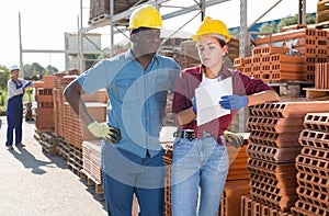 Couple of wokers checking order list at hardware store