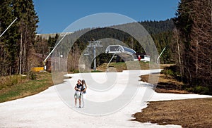 Couple woman and man in stylish casual clothes standing in the snow in the mountains on the background of beautiful scenery of the