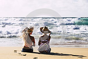 Couple of women friends in travel summer holiday vacation relax and enjoy the outdoor leisure at the beach sitting on the sand and