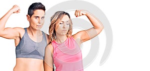 Couple of women wearing sportswear strong person showing arm muscle, confident and proud of power