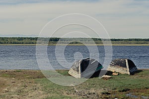 A couple of wooden boats are drying on the banks of the Barguzin River.