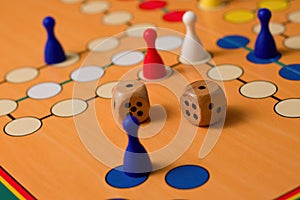 Couple of wooden dices on Ludo board