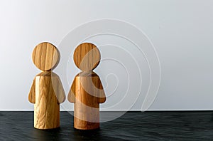 A couple of wooden figurines standing on a table against a white copy space