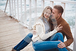 Couple on wooden pier near the sea in autumn