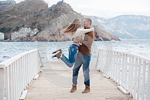 Couple on wooden pier near the sea in autumn