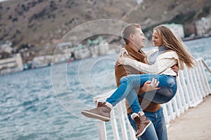 Couple on wooden pier near the sea in autumn