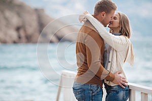 Couple on wooden pier near the sea in autumn