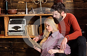 Couple in wooden vintage interior enjoy poetry. Romantic evening concept. Lady and man with beard on dreamy faces with