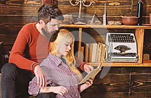 Couple in wooden vintage interior enjoy poetry. Romantic evening concept. Lady and man with beard on dreamy faces with