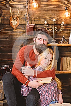 Couple in wooden vintage interior enjoy poetry. Romantic evening concept. Lady and man with beard on dreamy faces hugs