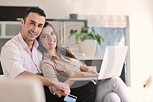 Couple work on laptop computer at modern home