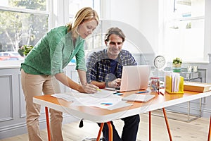 Couple Working Together At Desk In Home Office