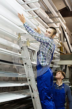 Couple of workmen choosing window PVC