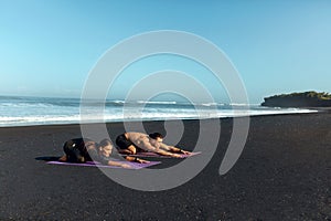 Couple Workout On Beach. Handsome Man And Sexy Woman In Fashion Sporty Outfit Stretching On Yoga Mat In Morning.