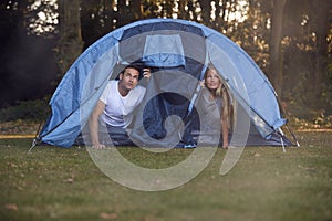 Couple Worried About Weather Looking Out Of Tent On Camping Trip In Countryside Together photo