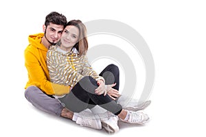Couple in yellow hugging and sittin in white studio