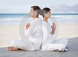 Couple, yoga and beach with meditation, sitting and peace on sand in morning with mindfulness in summer. Man, woman and