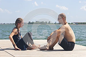 Couple Yoga, man and woman doing yoga exercises in the park