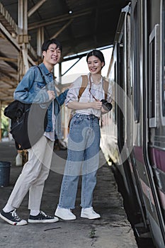 Couple Young asian traveler tourist by train Choose a trip and booking train queue by smartphone. Two Backpacker at