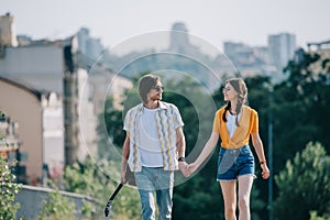 Couple of young friends walking and holding hands