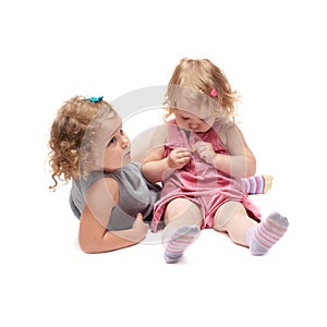 Couple of young little girl sitting over isolated white background