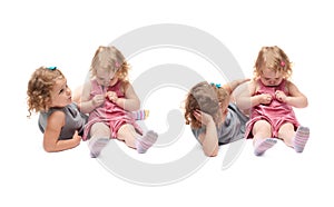 Couple of young little girl sitting over isolated white background