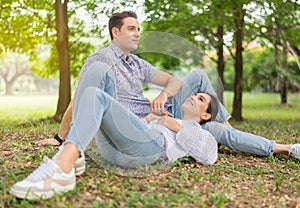 Couple young lover lying down on green grass in park together,Romantic and enjoying in moment of happiness time,Happy and smiling,