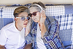 Couple young and old grandmother and teenager nephew family time together listen music with earphones and enjoy the day. Happy