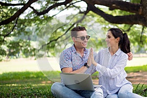 Couple young teen lover hands clapping and using laptop computer together at park,Romantic and enjoying in moment of happiness tim