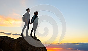 Couple of Young Travelers Standing on the Top of the Rock at Summer Sunset. Family Travel and Adventure Concept