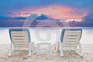 Couples of chairs beach on white sand with dusky sky background