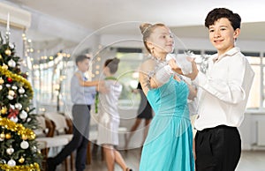 Couples dancing - teenagers in festive clothes dance the Viennese waltz near Christmas tree