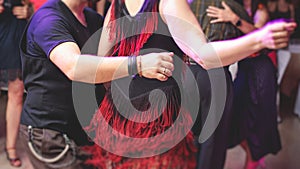 Couples dancing traditional latin argentinian dance milonga in the ballroom, tango salsa bachata kizomba lesson in the red and