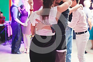 Couples dancing traditional latin argentinian dance milonga in the ballroom, tango salsa bachata kizomba lesson in the red and