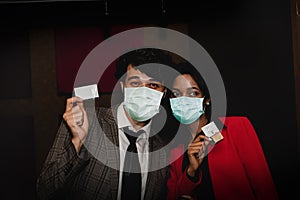 Couples of different nationalities watch movies happily, put on a movie theater mask.