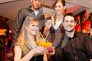 Couples drinking cocktails in bar